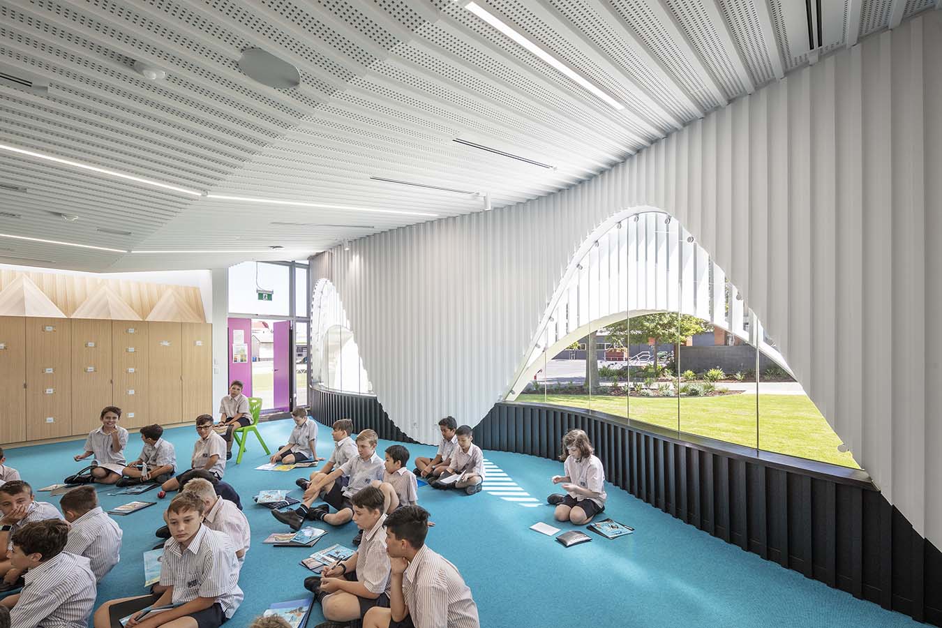Students sitting on the vibrantly coloured, carpeted floor of one of the classrooms in the PEGS Music Centre. Photo by John Gollings