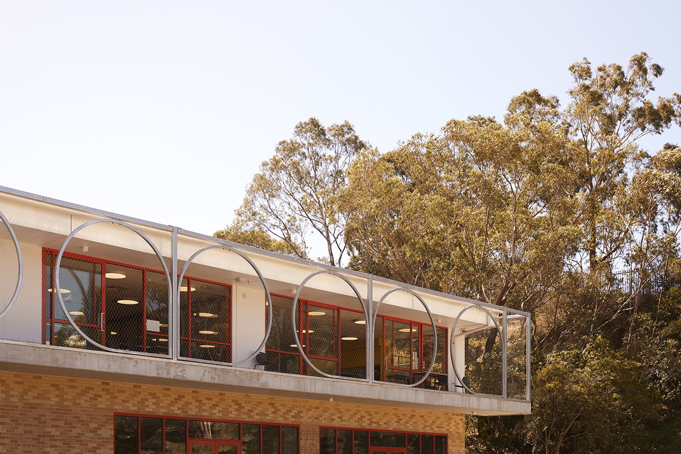 Delicate steel goggles frame views out toward the rest of the school campus, echoing the wattle motif and school logo
