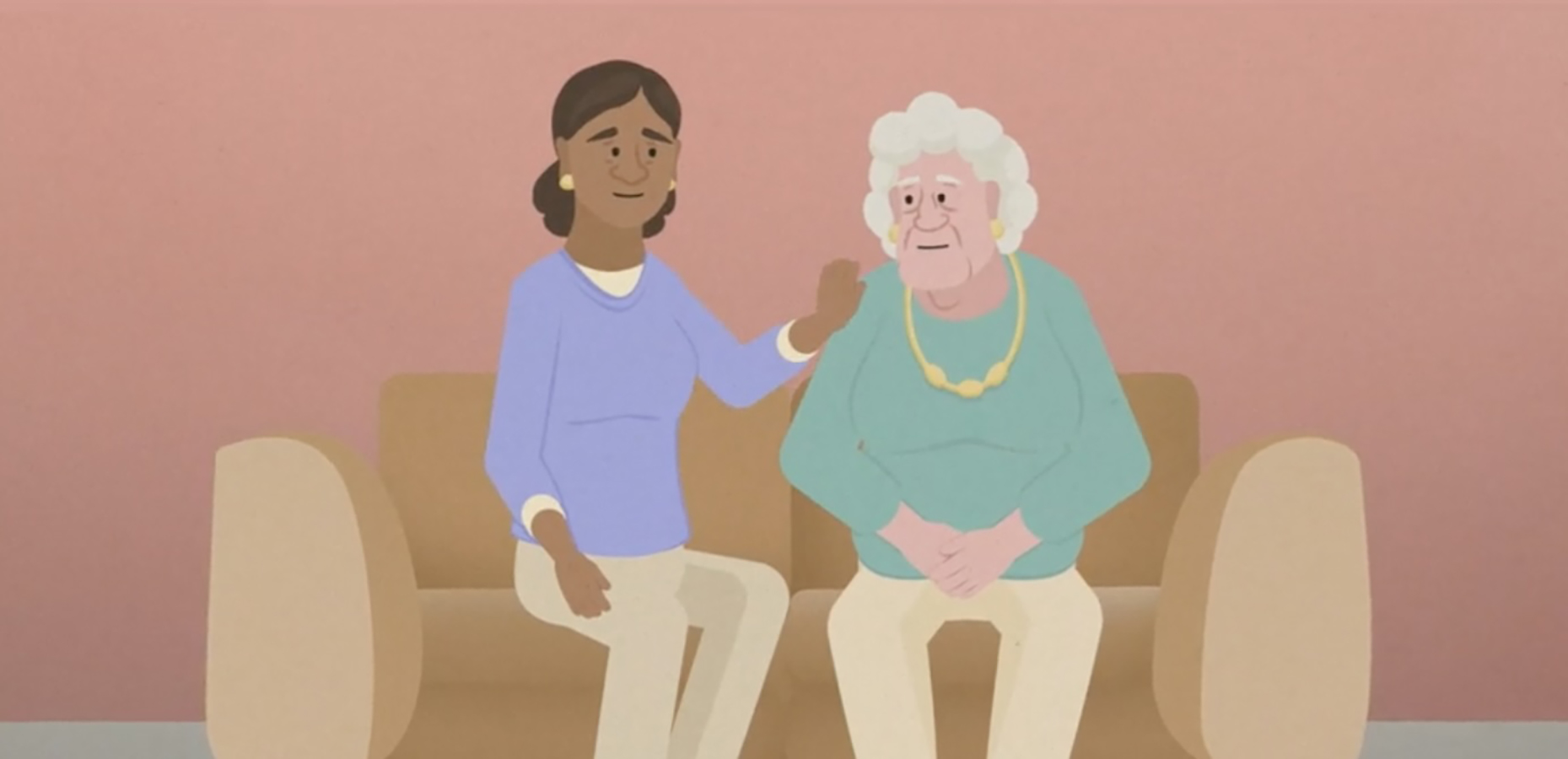 An older and younger woman sit on a coach together. The younger woman is comforting the older woman.