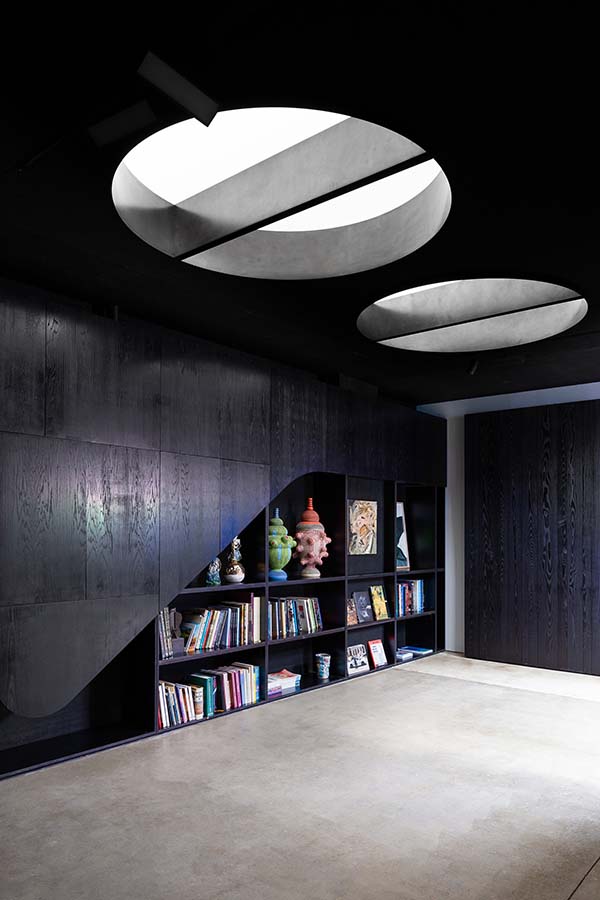 Two blackened steel oculi provide a natural glow of light into the library and viewing room