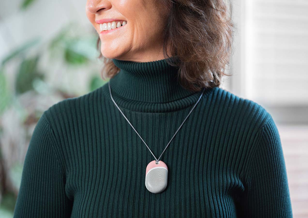 User wearing an Umps Link Pendant with an interchangeable case that is customised to suit their style