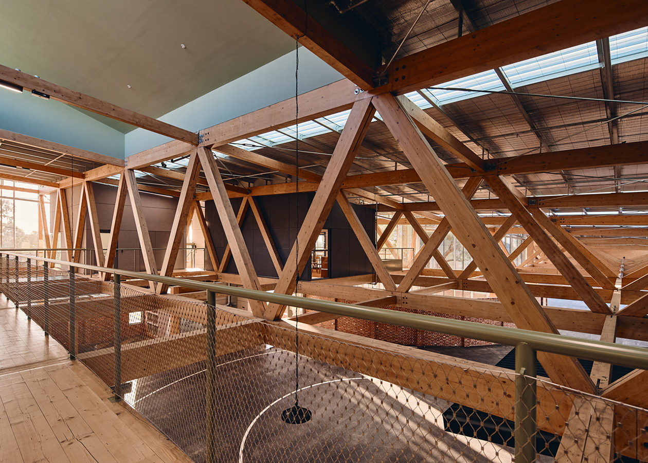 Unique timber trusses on the upper level reimagine the industrial building type.