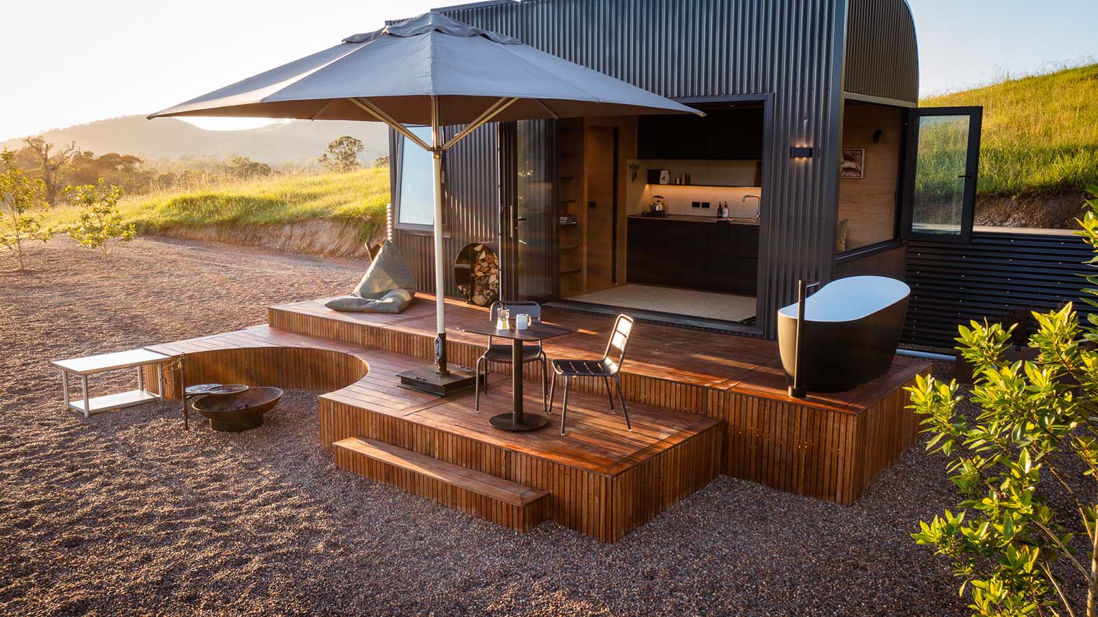 Black Sprout chairs and table overlooking green Australian hilly landscapes.