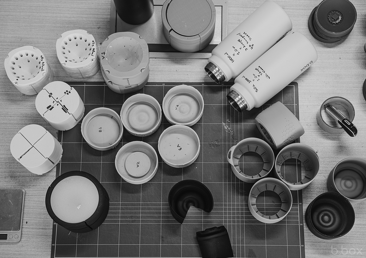 Top view of b.box bottle parts, test samples, and prototypes on a workbench showing stages of design and durability testing.