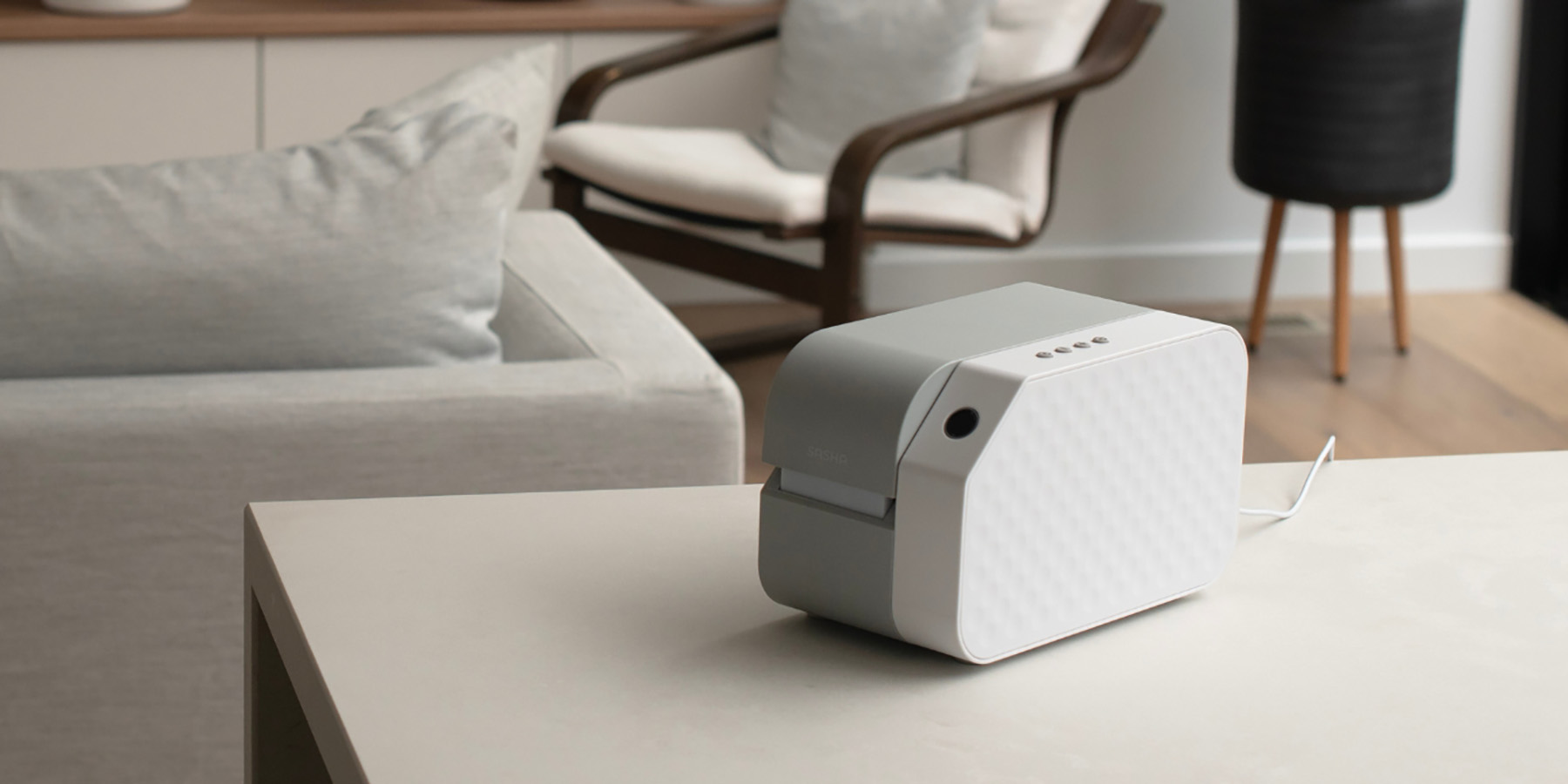 Small medication management device sitting on a side table next to a medication sachet, pills, and a glass of water.