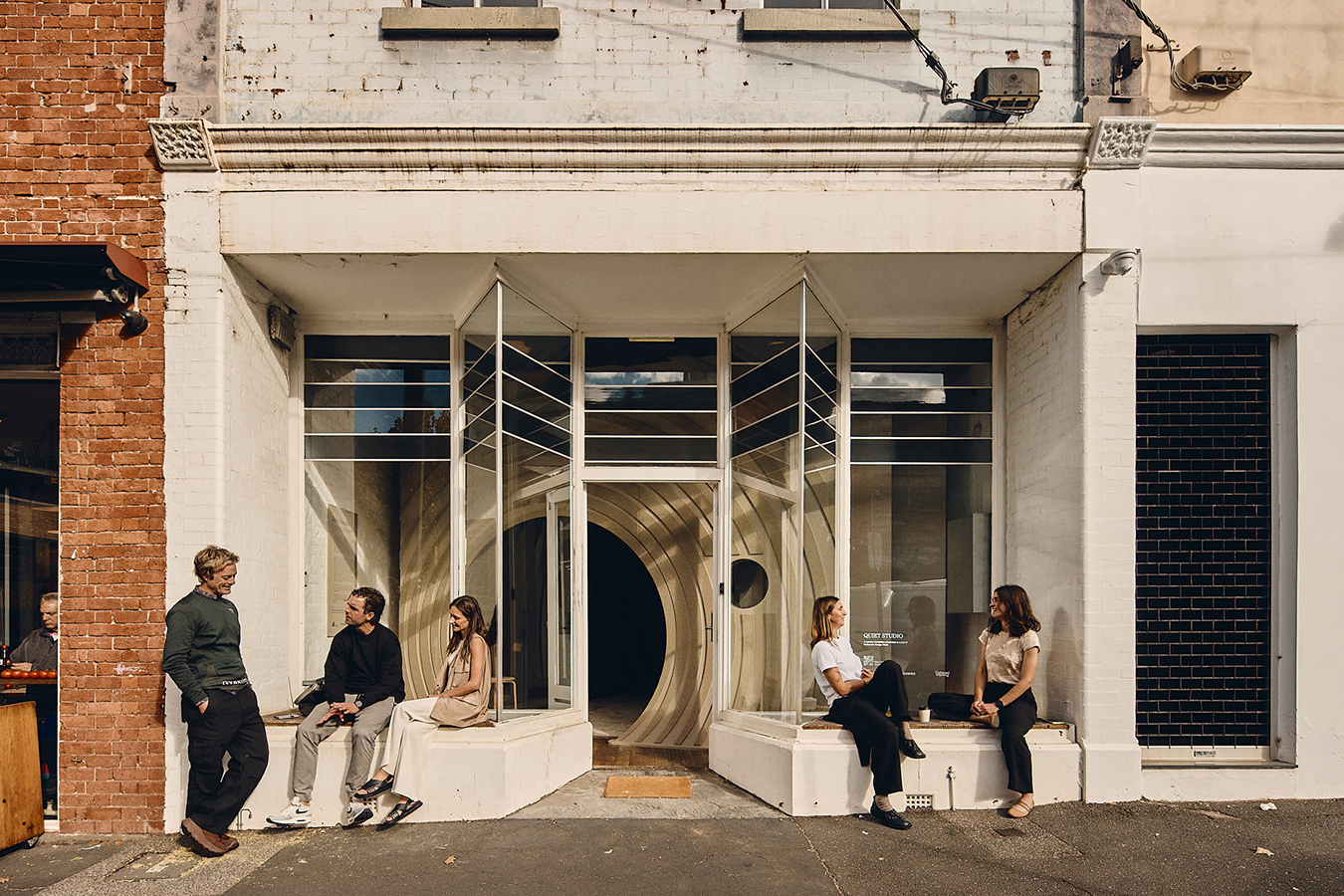 People chatting outside with curved interior visible.