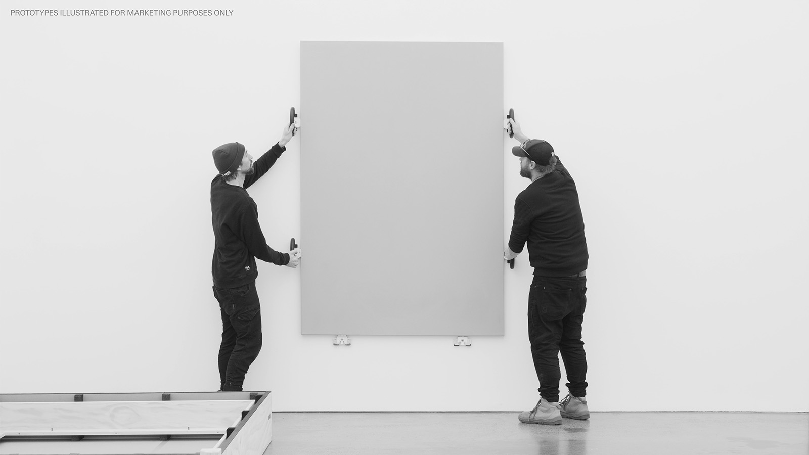 Artwork being installed to wall by two technicians supporting the work with AE Grips