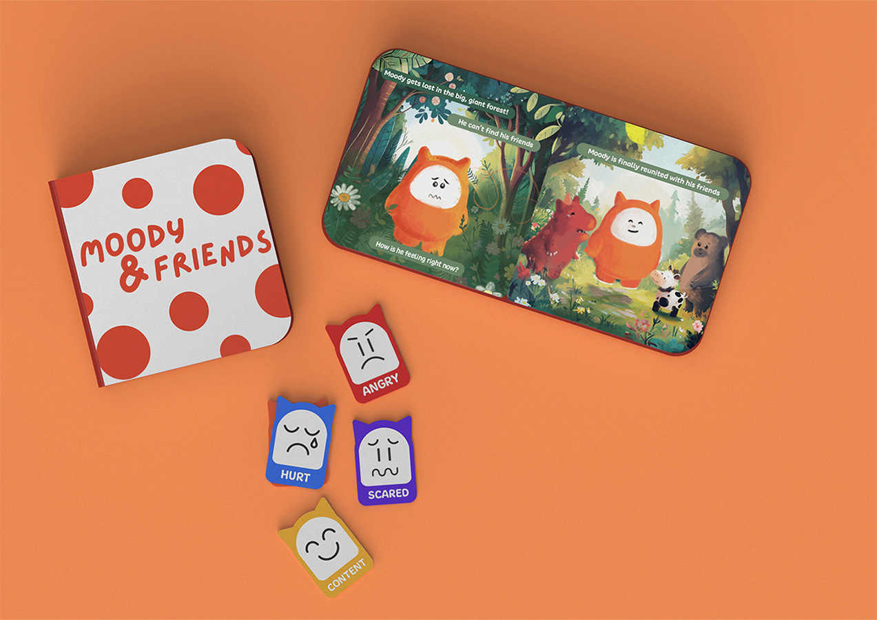 Two children’s storybooks, one open revealing colorful illustrations, sit beside scattered emotion cards with varied faces.