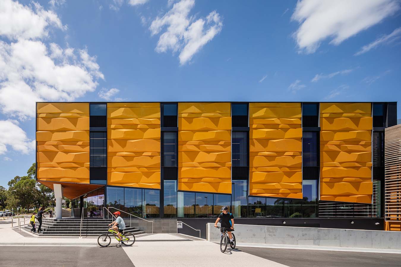 The northern facade features ochre coloured panels in vertical bands with glazing between.
