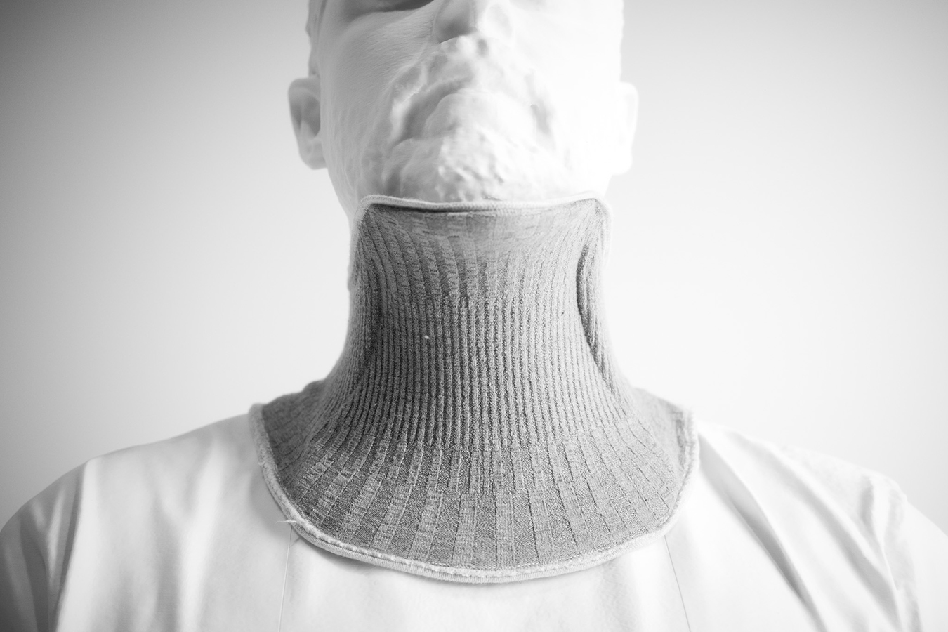Close-up of a manequin wearing a ribbed textile neck support collar, designed for comfort and stability in assistive care.