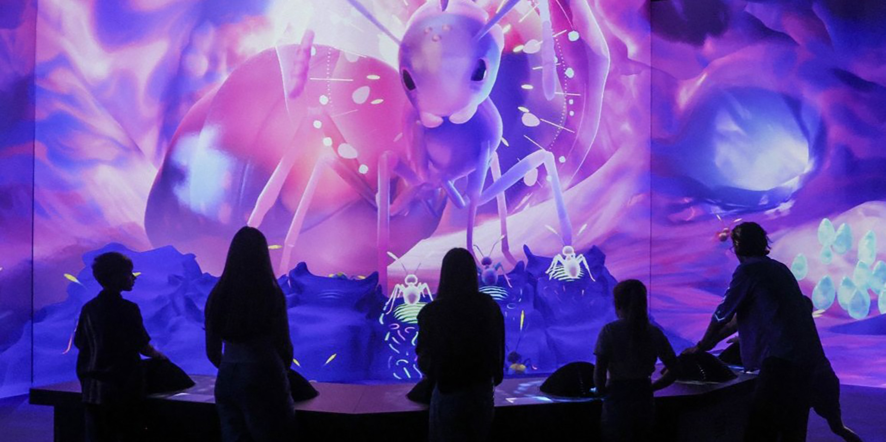 A group of exhibition visitors playing a game based on ant strigulation, to communicate with the Queen ant