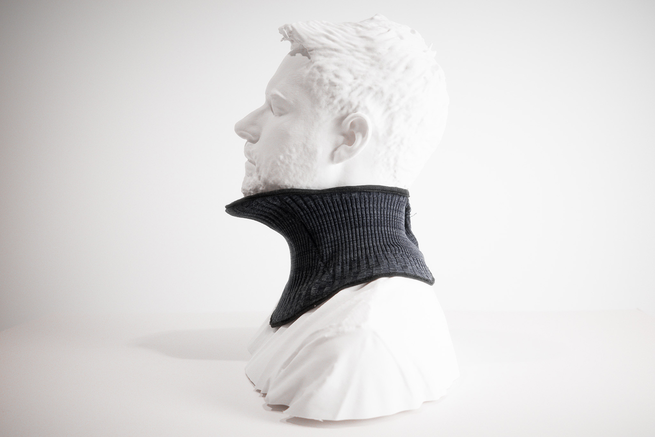 Side view of a manequin wearing a ribbed neck collar, gently contouring the neck and extends slightly below the collarbone