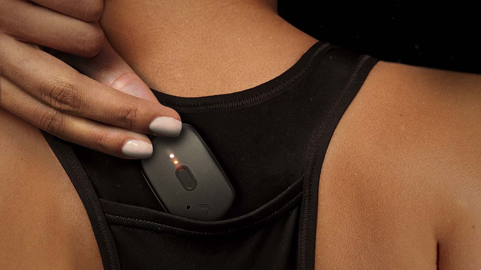 An image of a female basketball player placing the T7 device into the Basketball Jersey Pocket.