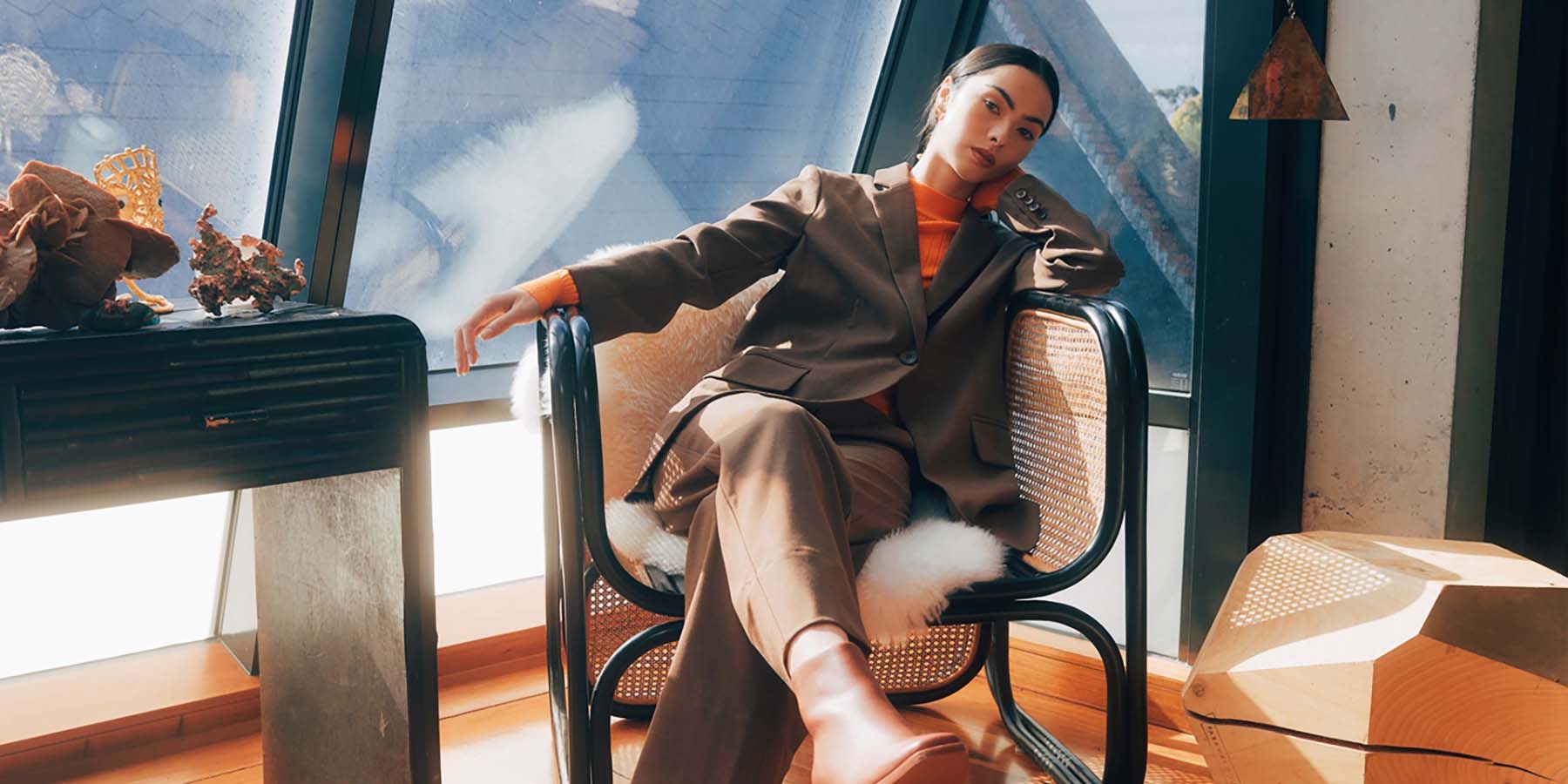 Person sitting in chair wearing a brown suit.